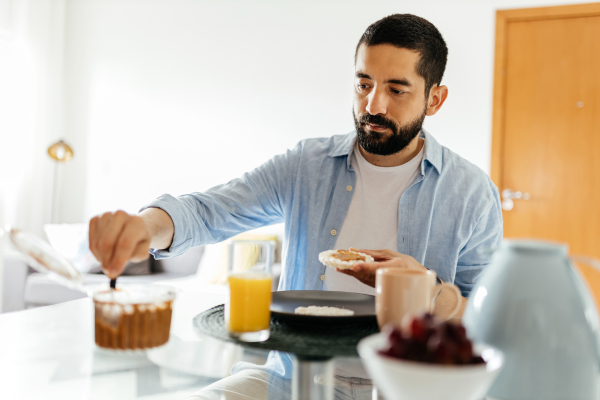Uomo che prepara una colazione proteica con burro di arachidi
