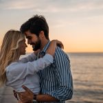 Coppia abbracciata al mare che rischia la trasmissione delle placche in gola durante il momento del bacio