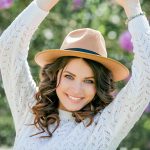 Donna accanto a siepi fiorite, in primavera, che si gode del tempo all’aria aperta durante il periodo del ciclo mestruale