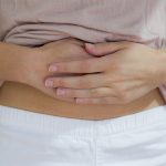 Donna che si tocca la pancia dopo avere avvertito dolore alla bocca dello stomaco