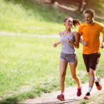 Una giovane coppia che corre al parco potrebbe soffrire di crampi ai muscoli