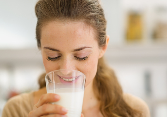 Donna che beve latte per assumere brufen 600