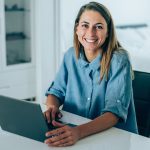 Donna che utilizza il computer a casa per sporgere richiesta dell’esenzione ticket online