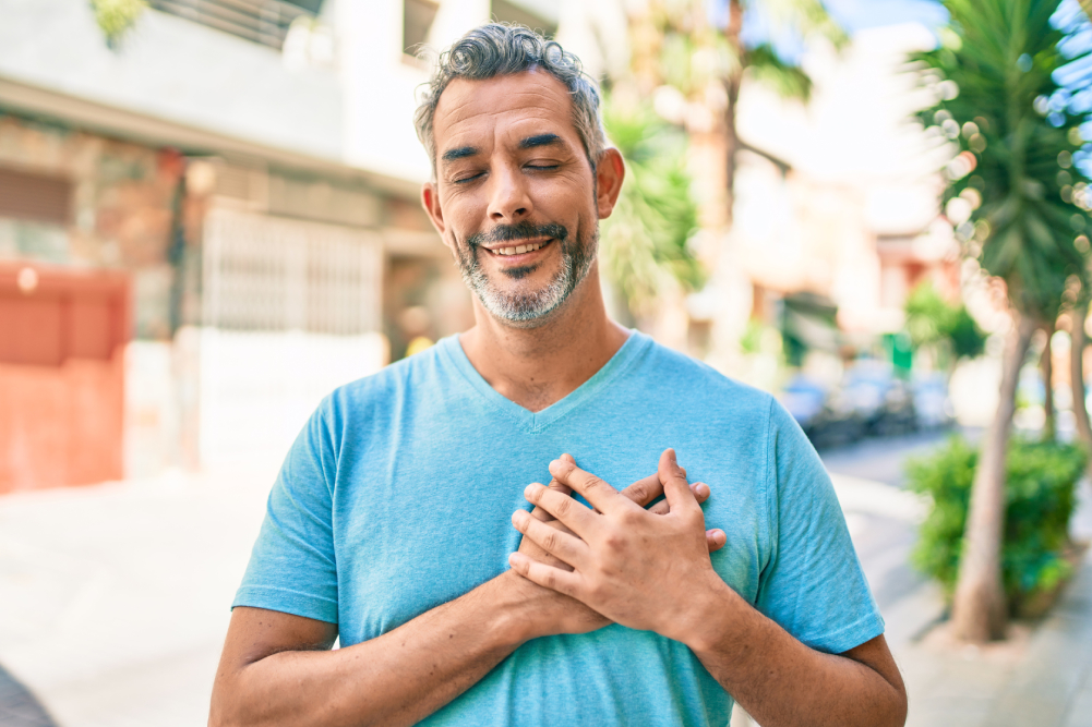 Uomo maturo sorride toccandosi il petto dopo intervento stenosi aortica