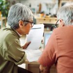 Coppia matura con documentazione per richiedere il rimborso per le spese mediche