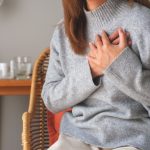 Donna con insufficienza cardiaca si tocca il petto per sintomo angina pectoris