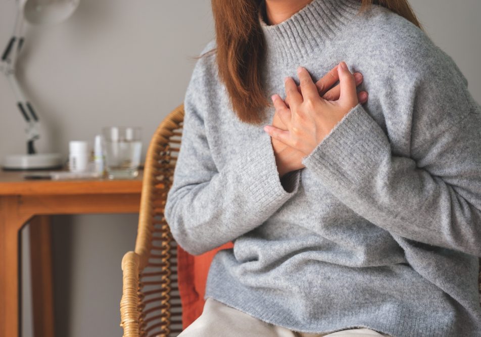 Donna con insufficienza cardiaca si tocca il petto per sintomo angina pectoris