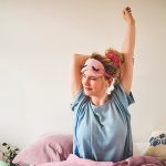 Donna che si risveglia riposata ed energica per affrontare una nuova giornata, dopo avere imparato il calcolo delle ore di sonno per i suoi bisogni