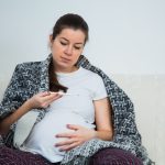 Donna che si misura la febbre per prendere il paracetamolo
