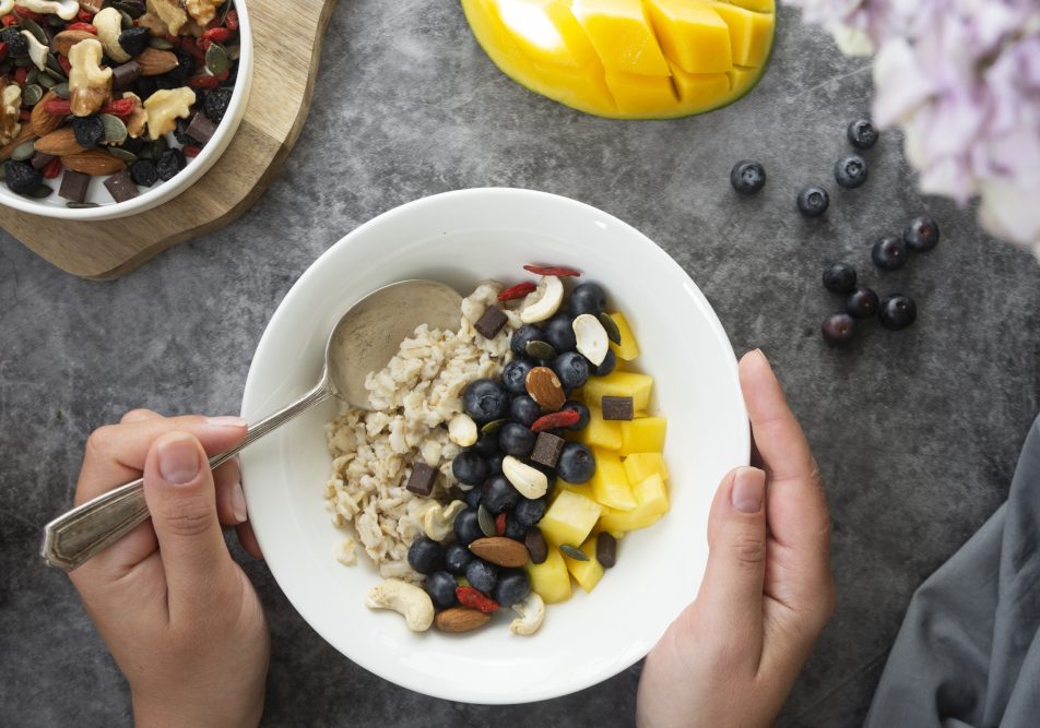 colazione-sana-con-frutta-secca Giovane donna prepara colazione sana con frutta secca