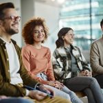 Gruppo di colleghi e collaboratori felici nella sala riunioni del loro ufficio, che partecipano a un meeting in cui viene approfondita l’importanza del welfare aziendale
