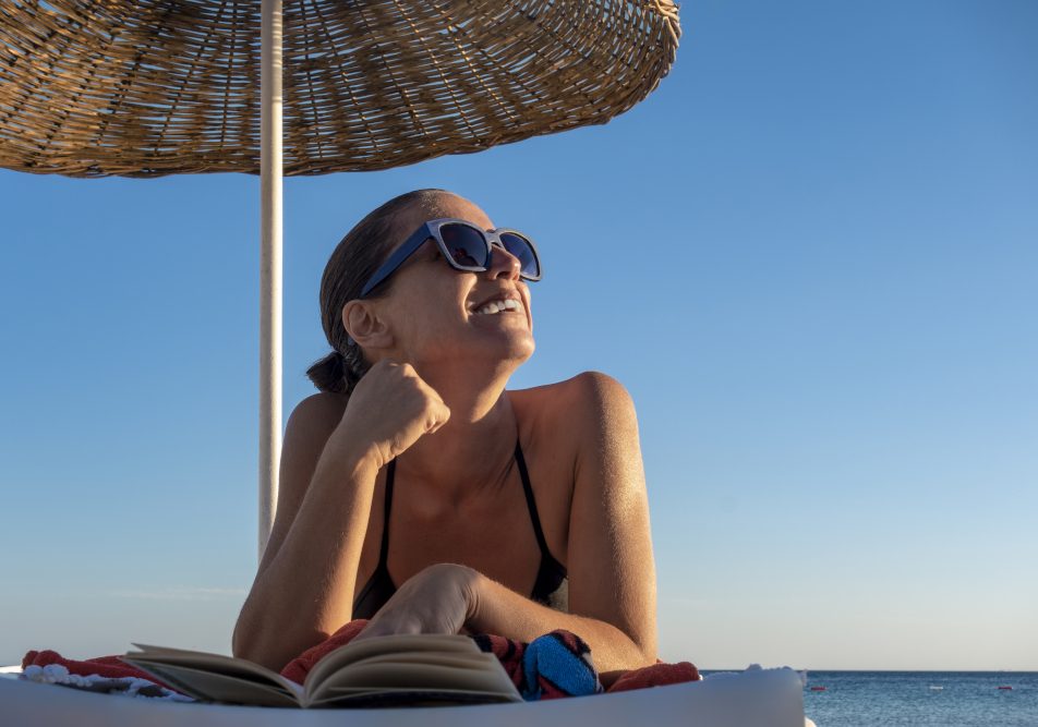 Giovane donna sotto il sole che si informa su come abbronzarsi velocemente