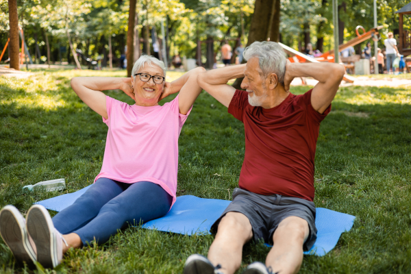 Coppia nel parco fa ginnastica dolce per anziani