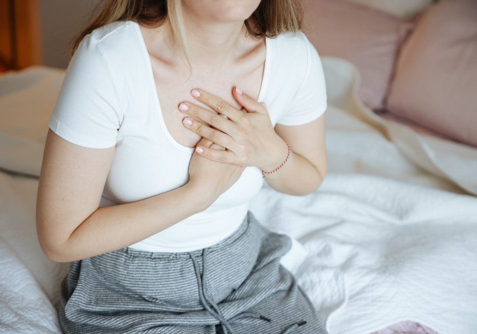 Giovane donna con tubercolosi si porta le mani al petto