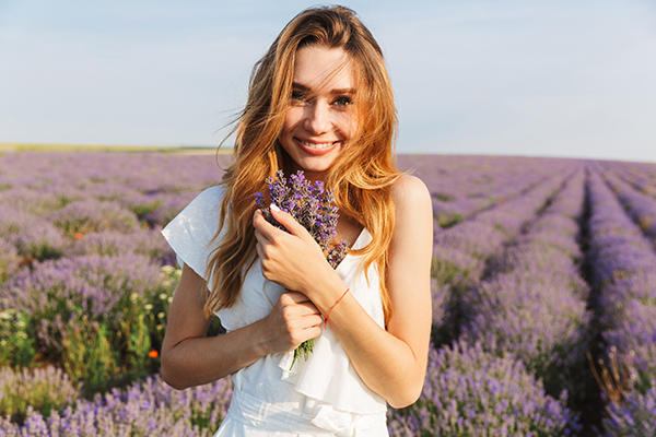 Giovane donna sorridente in mezzo ad un campo di lavanda, un sostituto naturale delle benzodiazepine