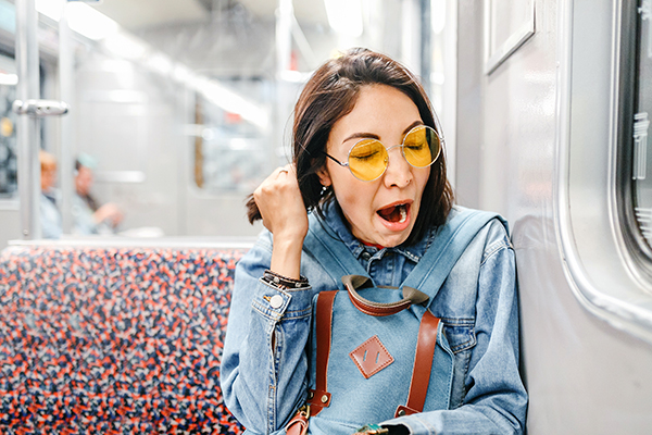 Donna che avverte sonnolenza mentre viaggia in treno, dovuta all’assunzione associata di benzodiazepine e antidepressivi