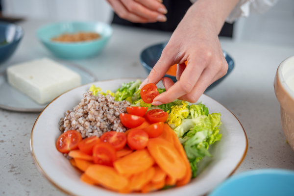 Donna prepara una cena light con verdure e cereali