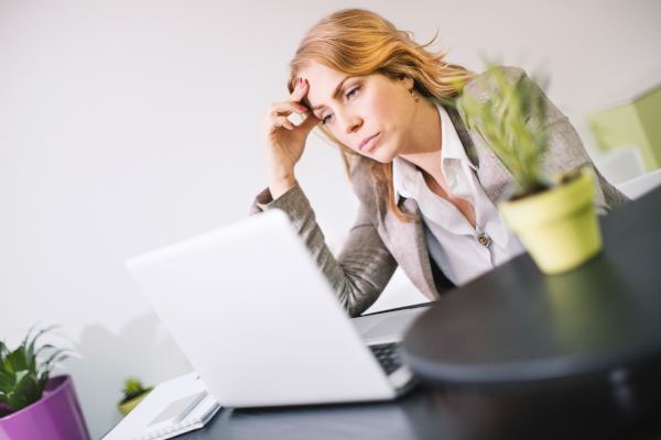 Donna in ufficio davanti al pc manifesta segni di stress lavorativo, tra le cause dell'ansia notturna