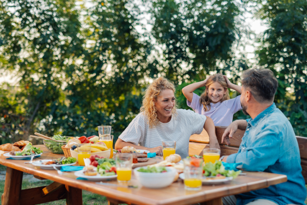 Famiglia all'aperto davanti a una tavola con cibo che fa parte di una dieta estiva
