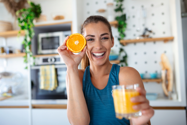 Giovane donna mangia agrumi contenenti vitamina C per la pelle