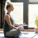 Giovane donna in casa sua pratica yoga come ginnastica dolce