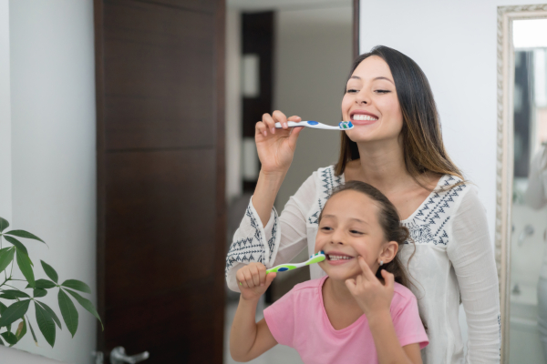 Mamma e figlia si lavano i denti con dentifricio senza fluoro