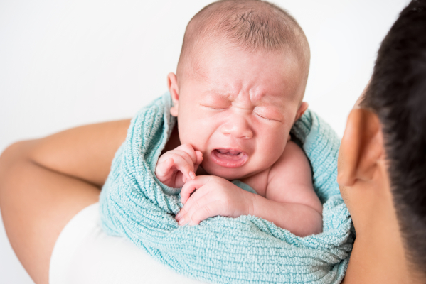 Neonato che piange in modo inconsolabile, tra i sintomi della meningite nei bambini