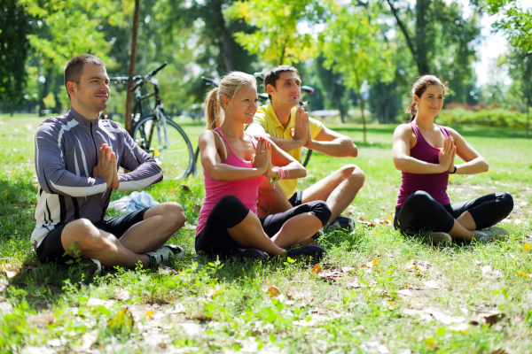 Persone che praticano yoga sul prato, come aiuto per evitare le paralisi notturne
