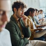 Uomo seduto in sala d’attesa per un colloquio di lavoro che avverte ansia sociale