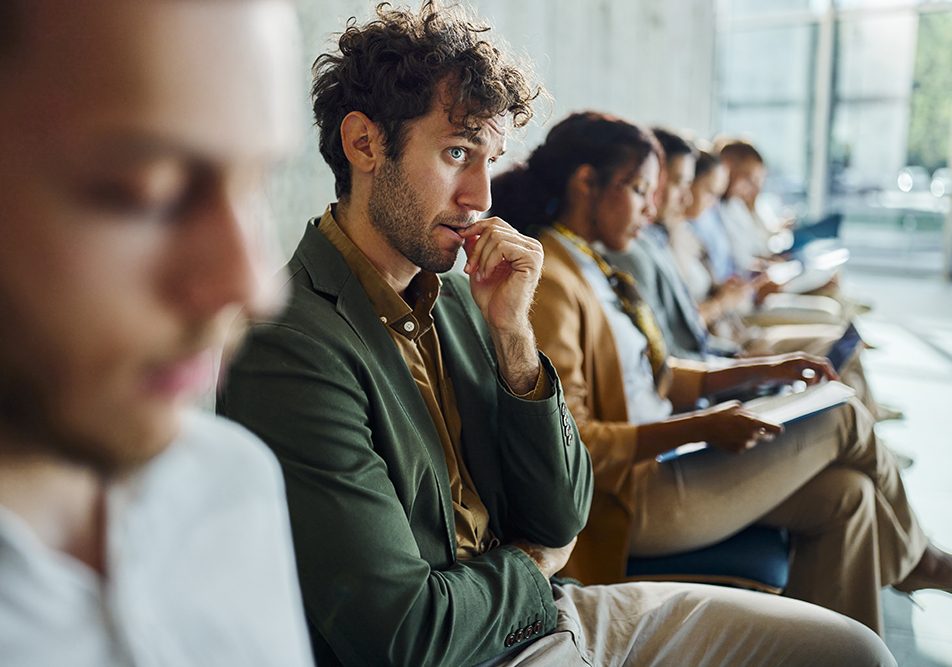 Uomo seduto in sala d’attesa per un colloquio di lavoro che avverte ansia sociale