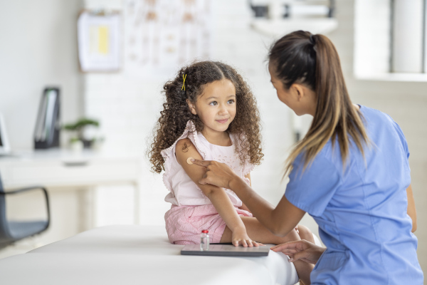Bambina nello studio del medico dopo aver ricevuto il vaccino antinfluenzale
