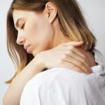 Donna con la mano sulla spalla che soffre di malattie reumatiche