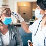 Medico misura febbre a paziente con sintomi covid