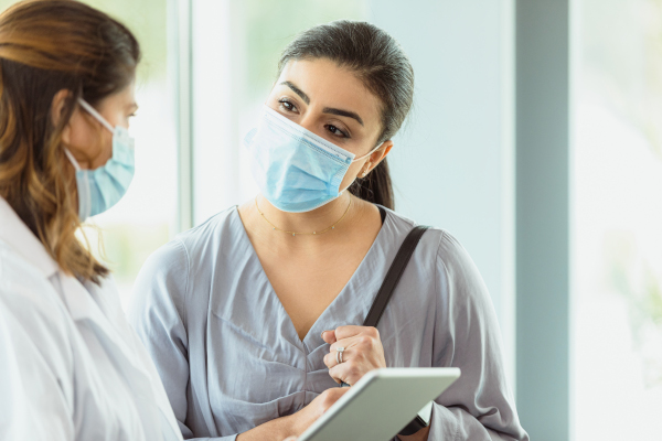 Donna e medico che indossano mascherina si confrontano per sintomi long covid