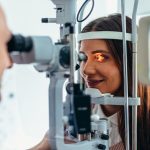 Giovane donna dall'oculista mentre esegue un intervento di laser agli occhi