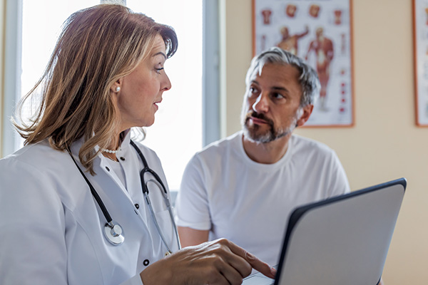 Dottoressa che legge l’anamnesi del paziente maturo, all’interno del suo studio, per valutare le funzioni cognitive del soggetto