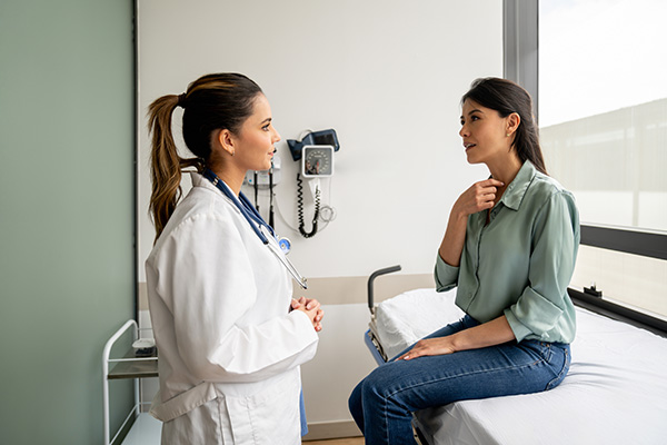 Dottoressa durante una visita medica che prepara la pazienta ad un’endoscopia digestiva, fornendole consulto e informazioni utili