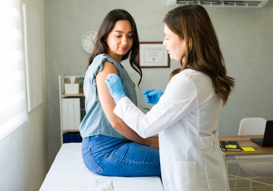 Giovane donna dal suo medico mentre si prepara a ricevere il vaccino antinfluenzale