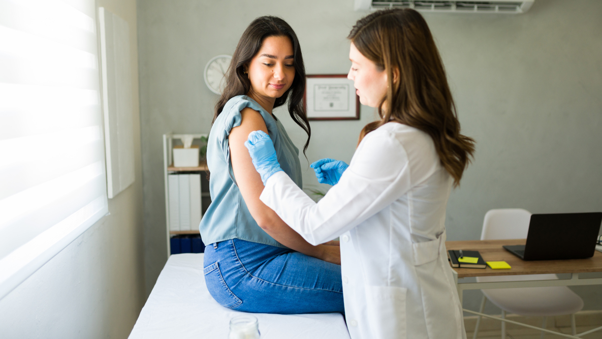 Giovane donna dal suo medico mentre si prepara a ricevere il vaccino antinfluenzale
