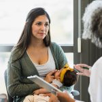 Madre presso la clinica medica insieme al suo bebè, consultando la dottoressa al fine di superare il baby blues
