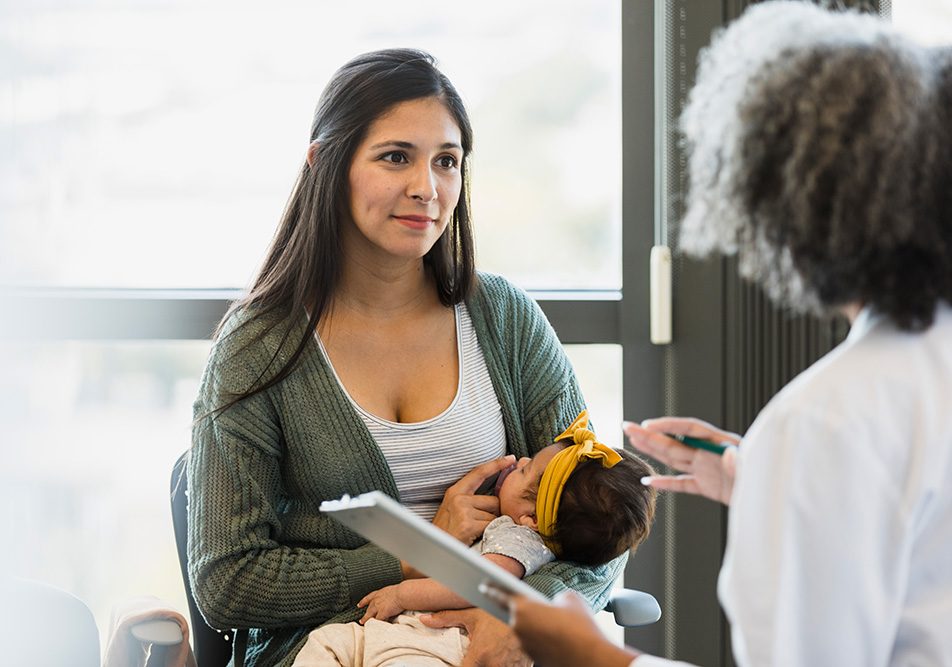 Madre presso la clinica medica insieme al suo bebè, consultando la dottoressa al fine di superare il baby blues