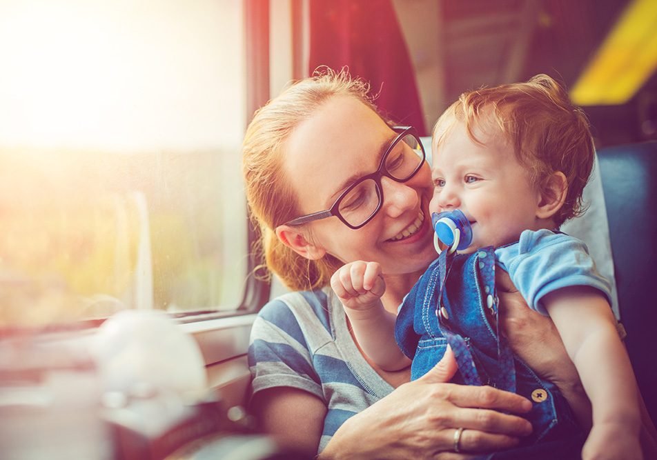 Mamma che viaggia serenamente con il suo bambino in treno, essendo informata su come togliergli il ciuccio senza provocare stress