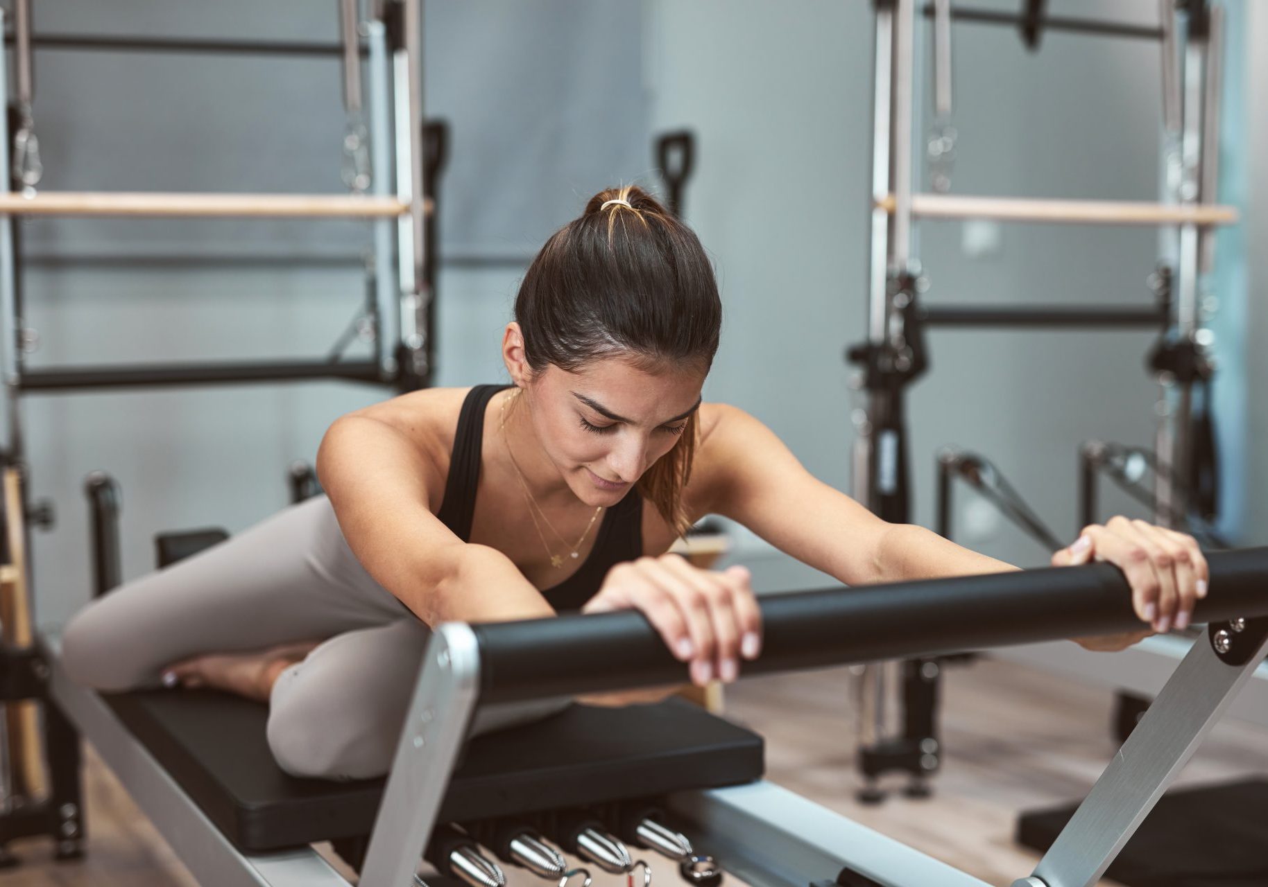 giovane donna esegue esercizio di pilates reformer