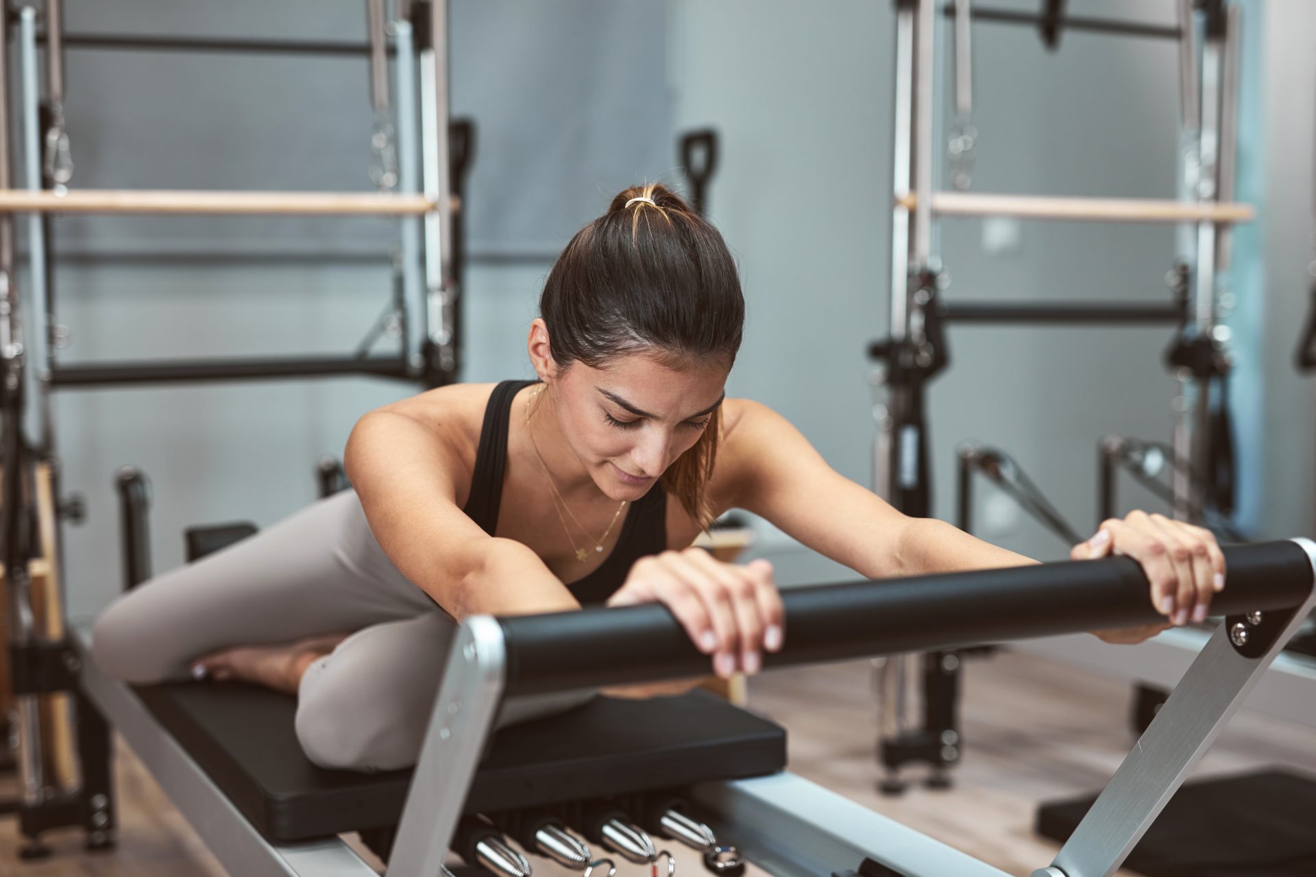 giovane donna esegue esercizio di pilates reformer