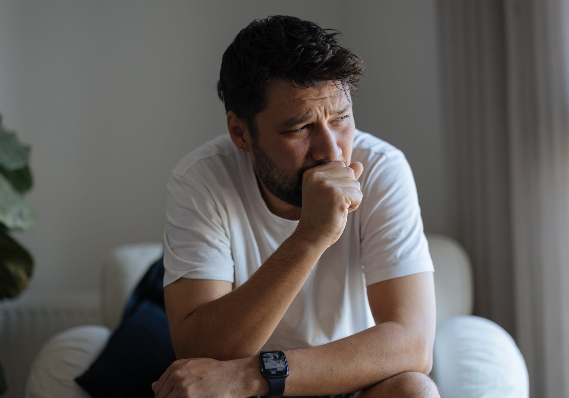 uomo seduto in poltrona tossisce