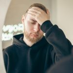 ragazzo con barba triste davanti allo specchio