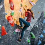 donna fa scalata sportiva indoor