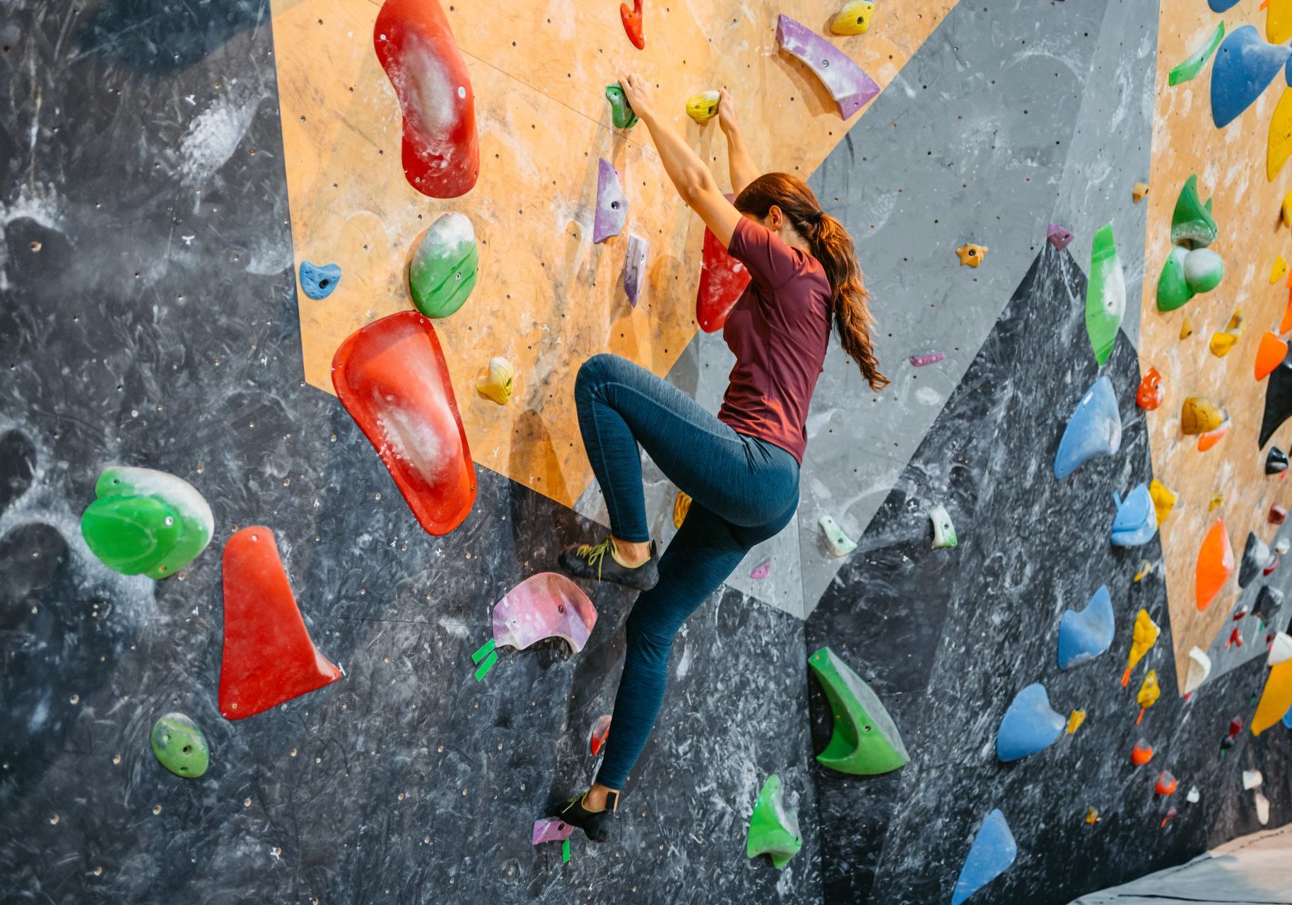 donna fa scalata sportiva indoor