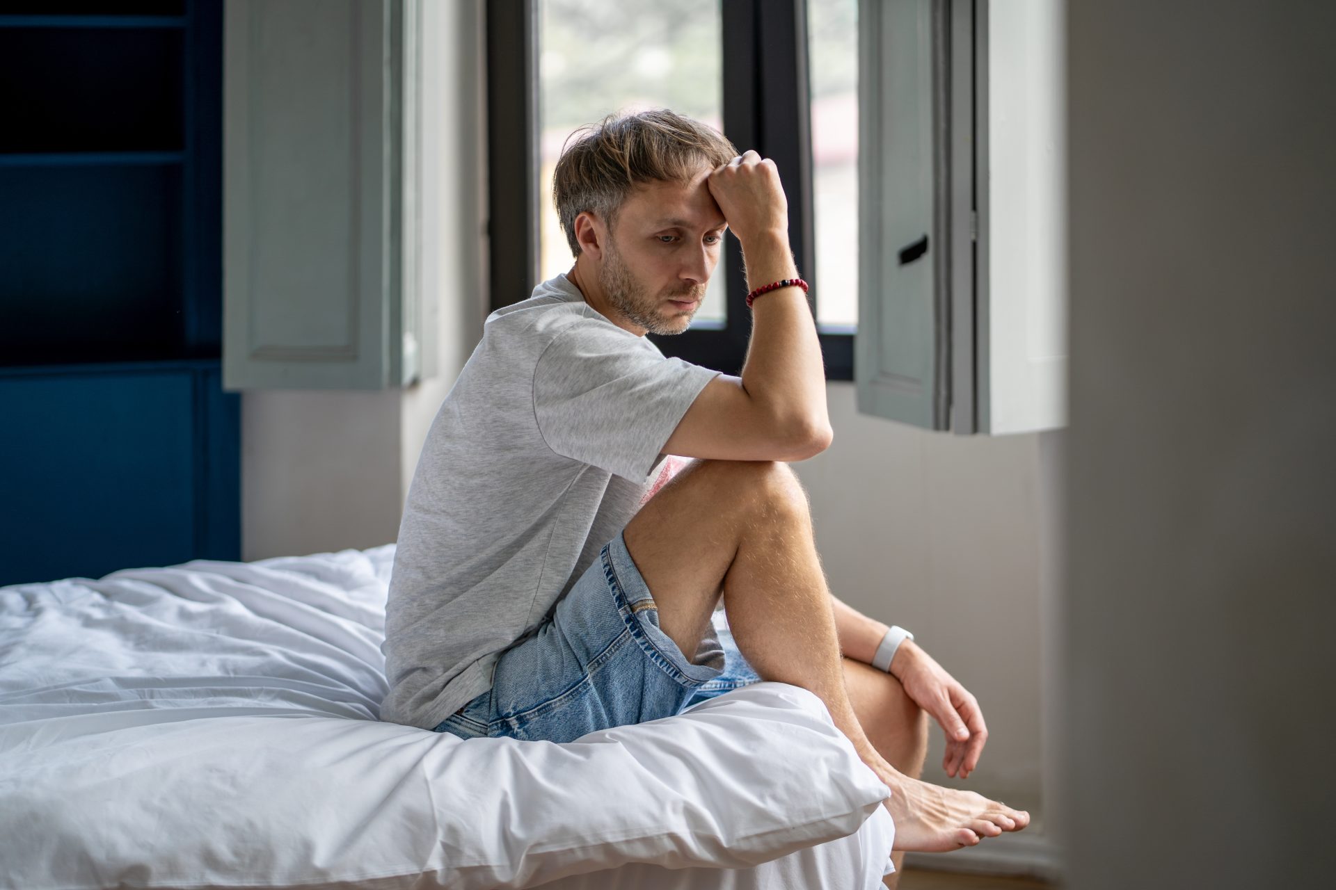uomo preoccupato seduto sul letto