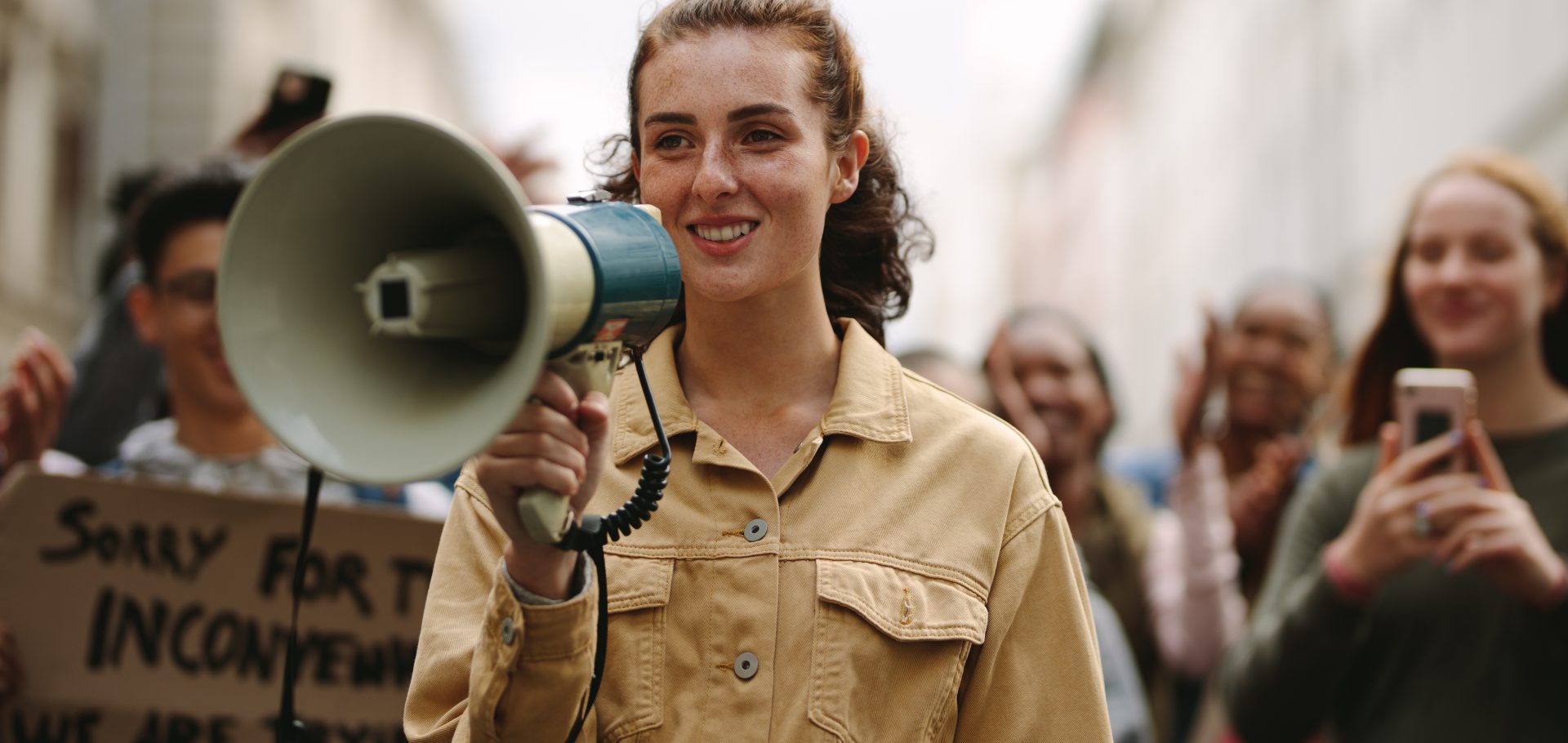 giovane donna con megafono durante manifestazione 